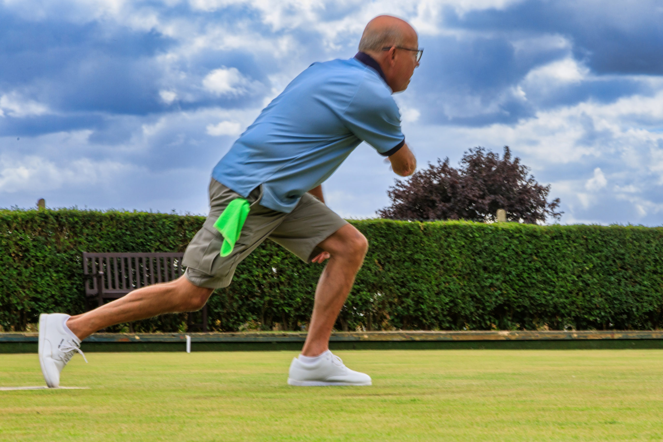 Playing the sport of lawn bowls at Aston Clinton Lawn Bowls Club Buckinghamshire with a crowd looking on